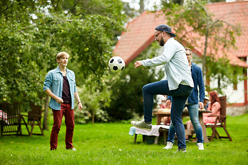 Image showing happy friends playing football at summer garden