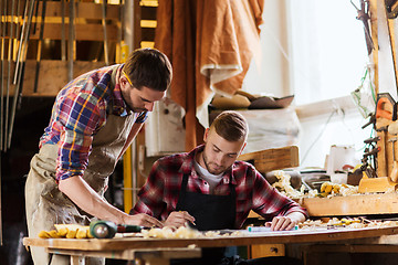 Image showing carpenters with ruler and blueprint at workshop