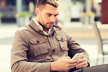 Image showing man with smartphone at city street cafe