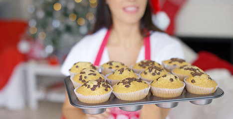 Image showing Young woman with a tray of Christmas cupcakes