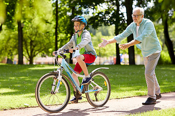 Image showing grandfather and boy with bicycle at summer park