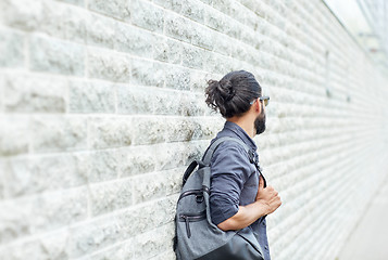 Image showing man with backpack standing at city street wall