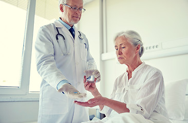 Image showing doctor giving medicine to senior woman at hospital