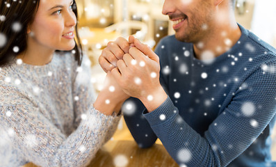 Image showing happy couple holding hands at restaurant or cafe