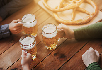 Image showing close up of hands with beer mugs at bar or pub