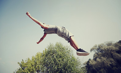 Image showing sporty young man jumping in summer park