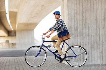 Image showing young hipster man with bag riding fixed gear bike