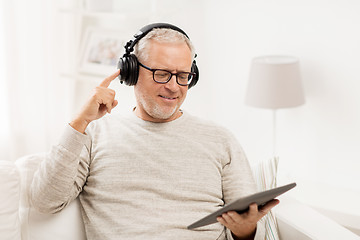 Image showing senior man with tablet pc and headphones at home