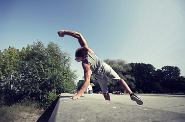 Image showing sporty young man jumping in summer park