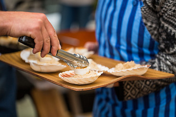 Image showing close up of scallop with garnish on seashell