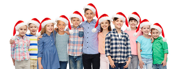 Image showing happy smiling children in santa hats hugging