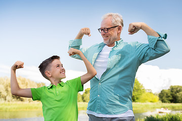 Image showing happy grandfather and grandson showing muscles