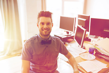 Image showing happy creative male office worker with computers