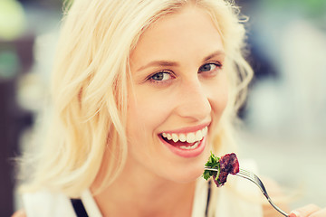 Image showing happy woman eating dinner at restaurant terrace