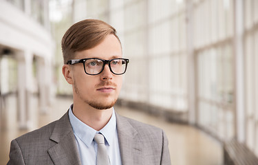 Image showing young businessman in suit and glasses at office