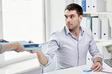 Image showing businessman taking folder from secretary in office