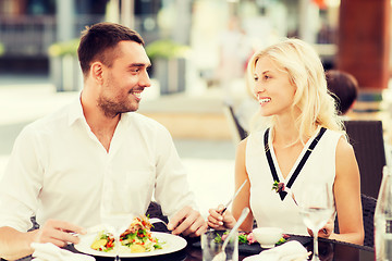 Image showing happy couple eating dinner at restaurant terrace