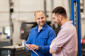 Image showing auto mechanic with clipboard and man at car shop