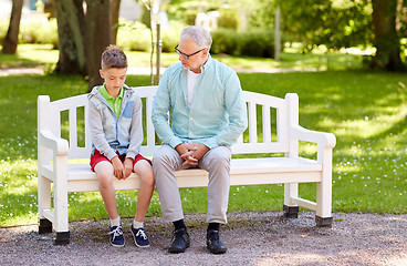 Image showing grandfather and grandson talking at summer park