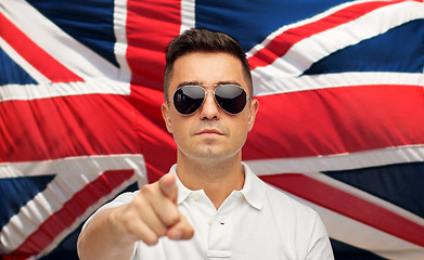 Image showing man in shades pointing finger over brittish flag