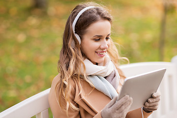 Image showing woman with tablet pc and headphones in autumn park
