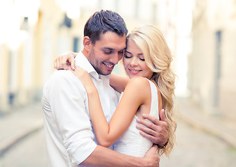 Image showing romantic happy couple hugging in the street