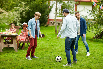Image showing happy friends playing football at summer garden