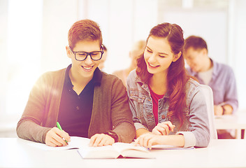 Image showing two teenagers with notebooks and book at school