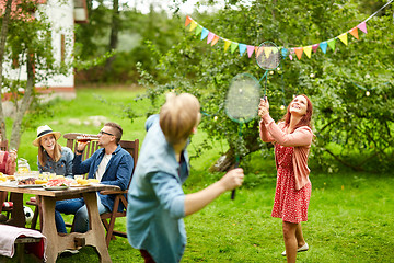 Image showing happy friends playing badminton at summer garden