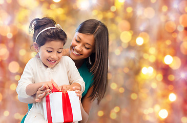 Image showing happy mother and girl with gift box over lights
