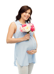 Image showing happy pregnant woman with flowers touching belly