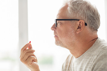 Image showing close up of senior man taking medicine pill