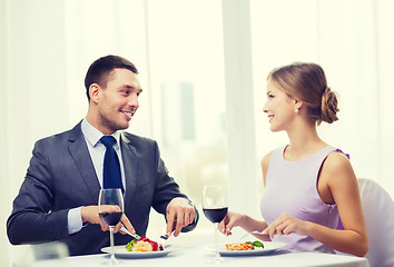 Image showing smiling couple eating main course at restaurant