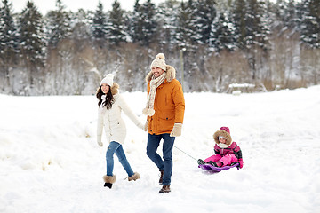 Image showing happy family with sled walking in winter forest