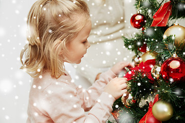 Image showing little girl decorating christmas tree at home