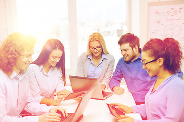 Image showing smiling team with laptop and table pc computers