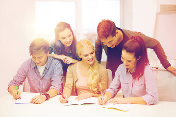 Image showing smiling students with notebooks at school