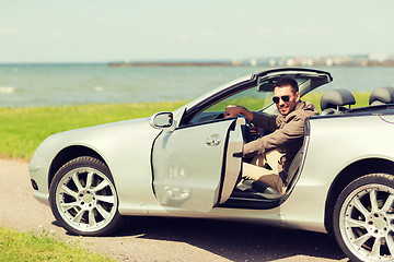 Image showing happy man opening door of cabriolet car outdoors