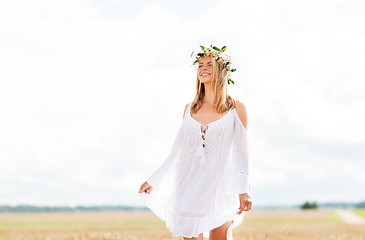 Image showing happy young woman in flower wreath on cereal field