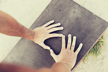 Image showing close up of man hands exercising on bench outdoors