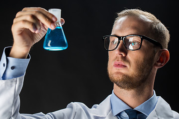 Image showing young scientist holding test flask with chemical