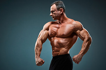 Image showing torso of attractive male body builder on gray background.