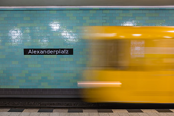 Image showing Yellow subway train in motion on Berlin Alexanderplatz underground station.