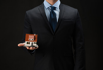 Image showing close up of businessman holding house model