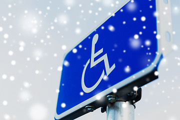 Image showing close up of road sign for disabled over snow