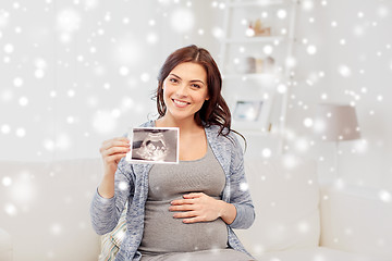 Image showing happy pregnant woman with ultrasound image at home