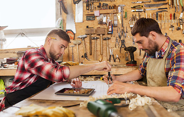 Image showing workmen with blueprint and dividers at workshop