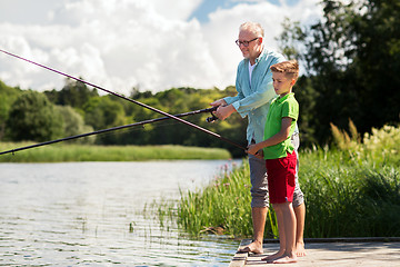 Image showing grandfather and grandson fishing on river berth