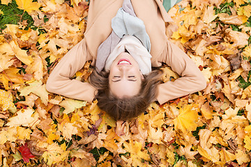 Image showing beautiful happy woman lying on autumn leaves