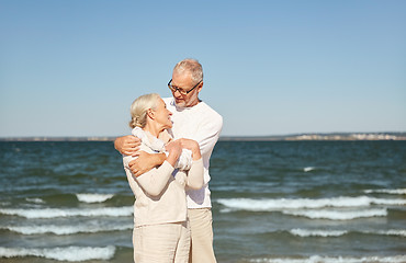 Image showing happy senior couple hugging on summer beach